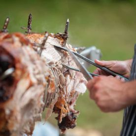 our chef carving a pig roast for an outdoor event